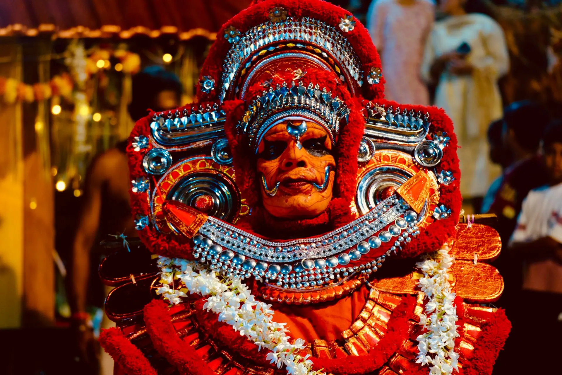 Colorful portrait of a traditional Theyyam performer in ornate attire with vivid makeup