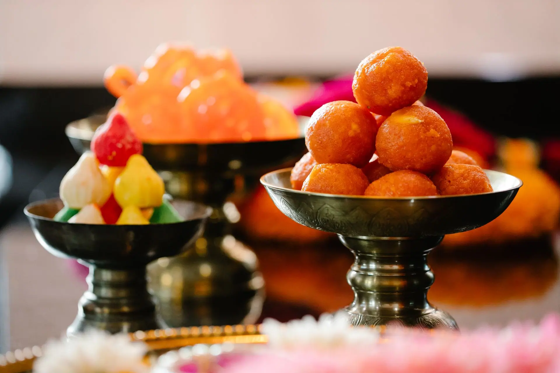Close-up of traditional Indian sweets beautifully arranged in ornate bowls, highlighting vibrant colors
