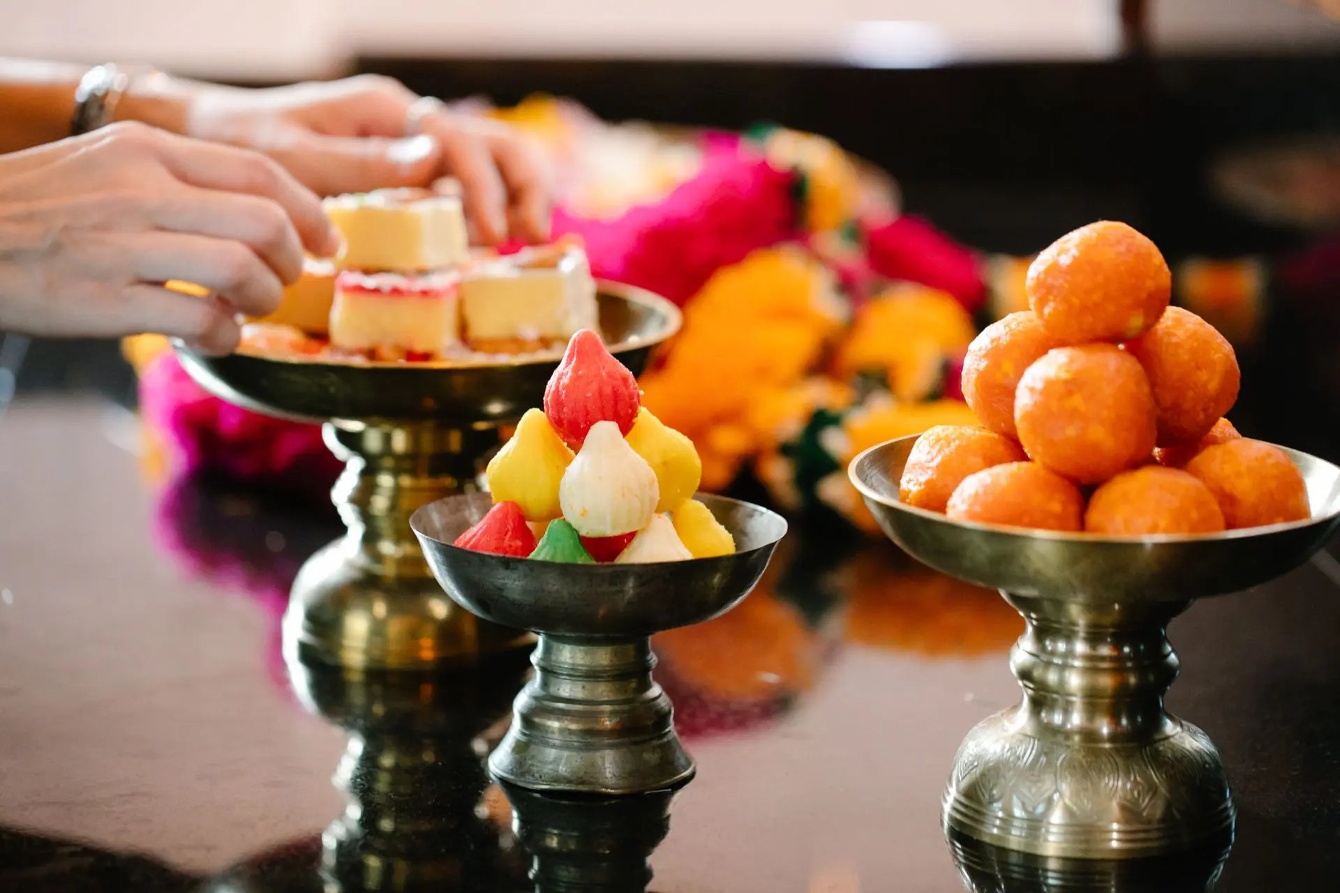 Colorful Indian sweets on brass platters, ideal for traditional celebrations