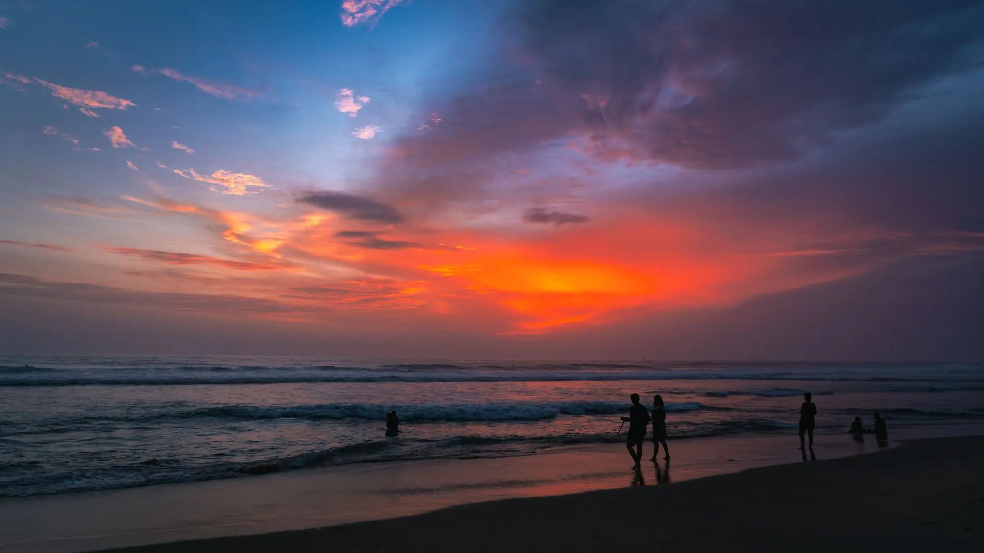 Capture the vibrant sunset hues at Varkala Beach, Kerala, with people enjoying the tranquil scenery