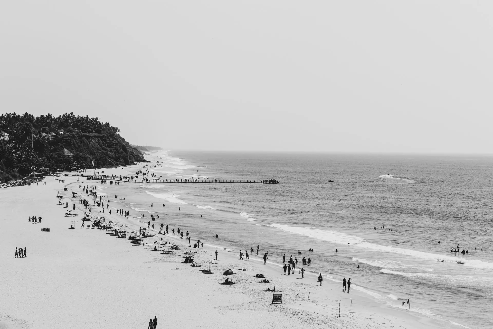 Stunning aerial black and white photograph of Varkala Beach, India, capturing people enjoying the seaside