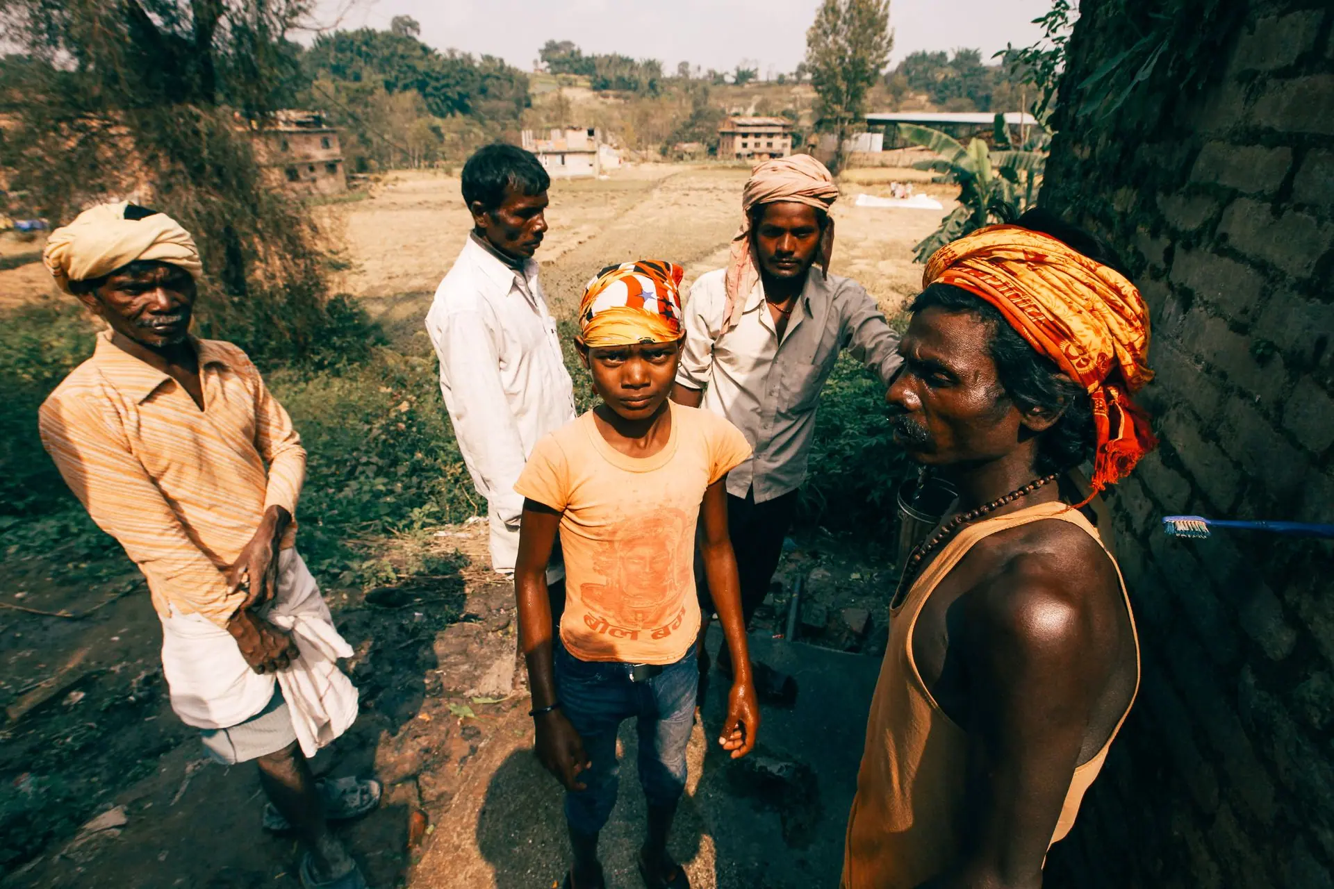 A group of Indian men and a boy in traditional attire in a village setting, depicting rural life
