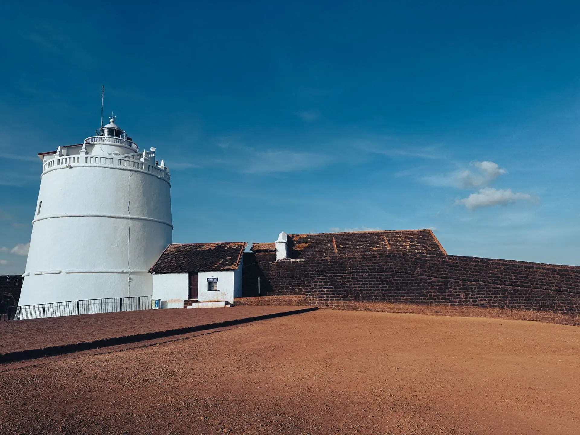 Majestic Portuguese-style lighthouse at Fort Aguada in Goa, under blue skies