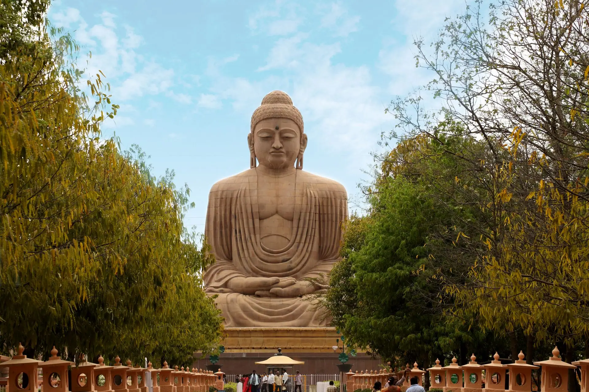 An awe-inspiring view of the Great Buddha Statue in Bodh Gaya, surrounded by lush greenery