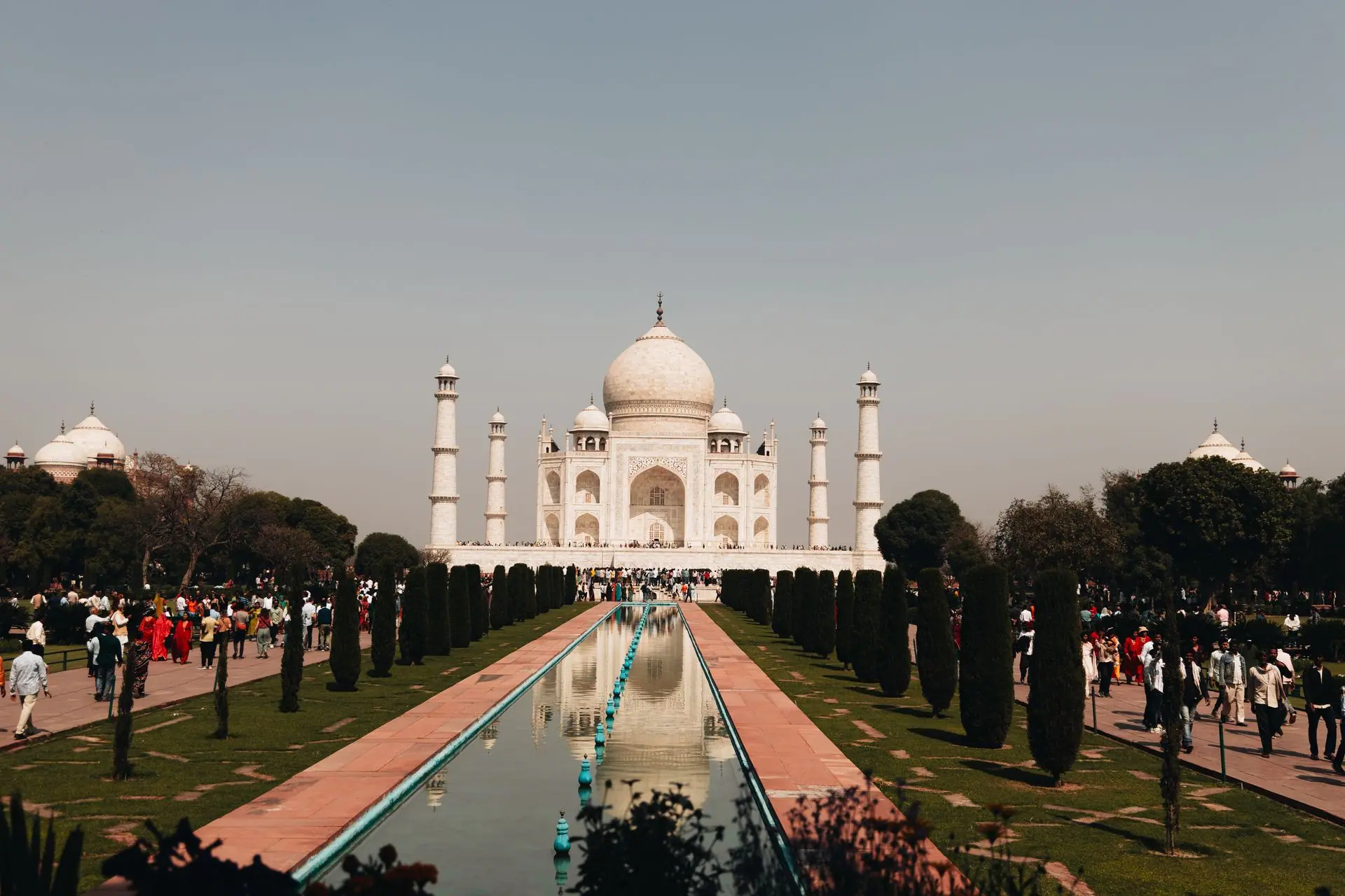 A beautiful view of the Taj Mahal with tourists and reflection in Agra, India