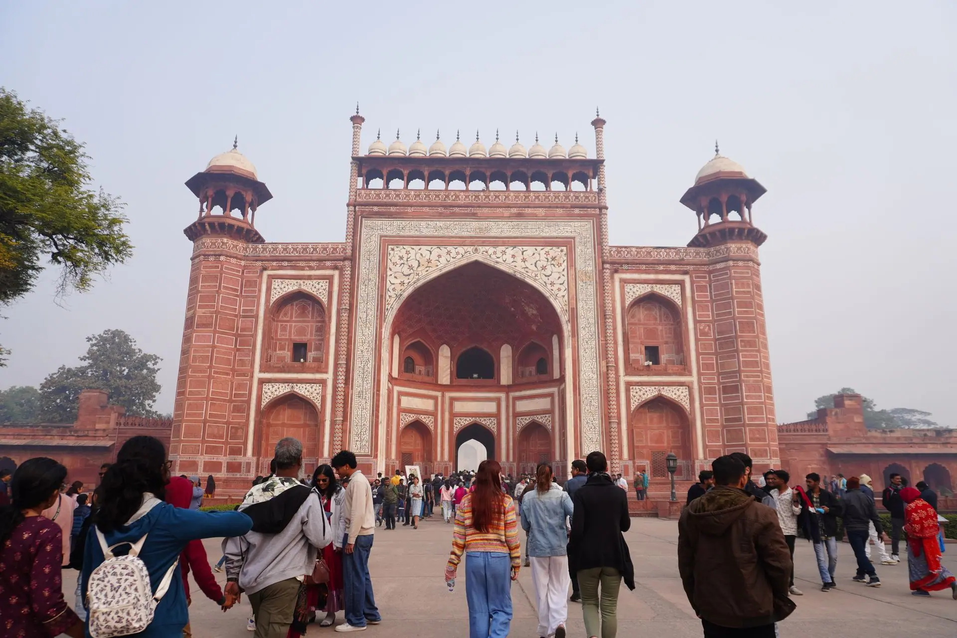 Crowd of visitors at the grand entrance of Agra Fort on a clear day
