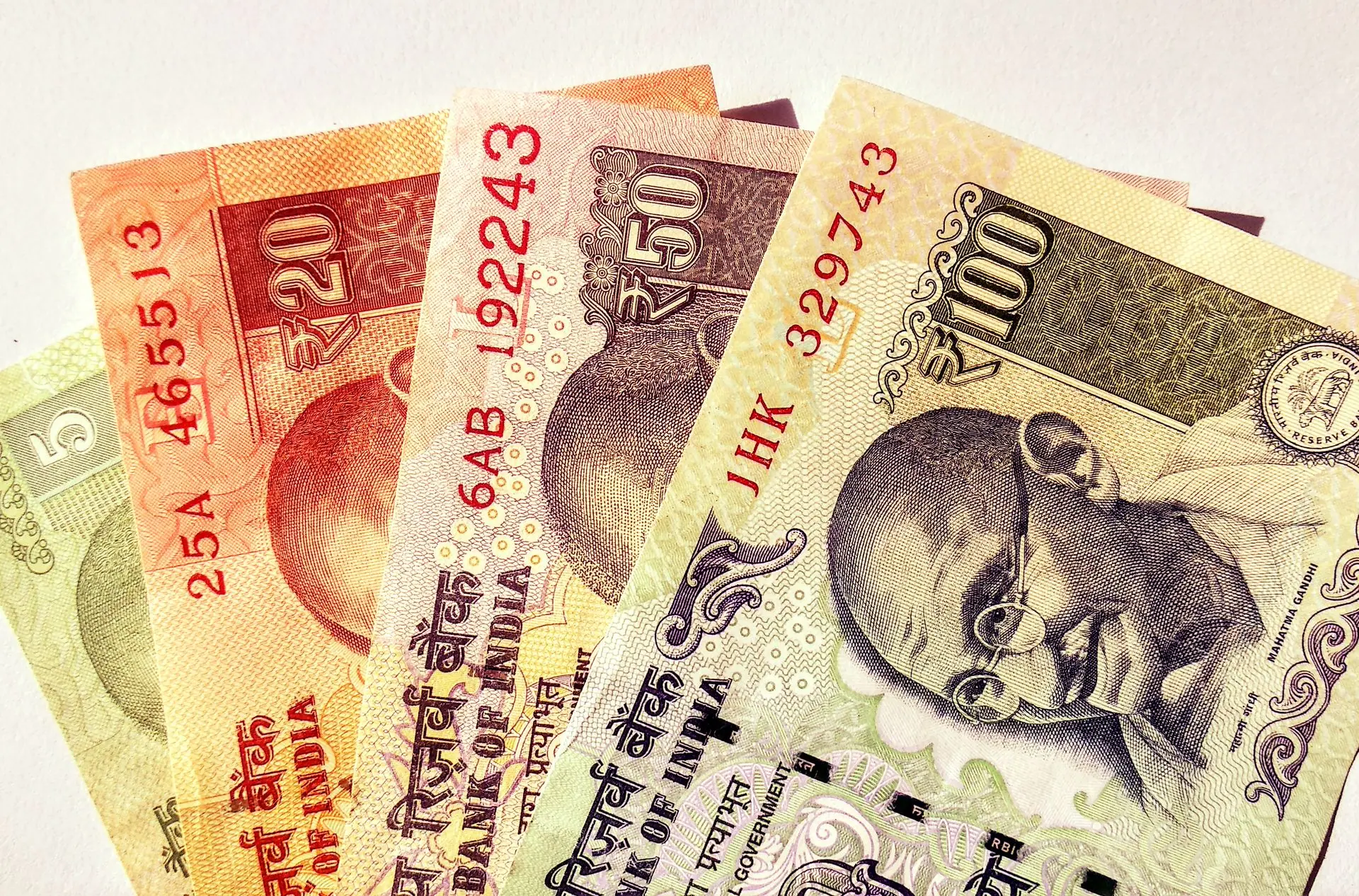 Close-up image of Indian rupee banknotes in various denominations, showcasing currency design