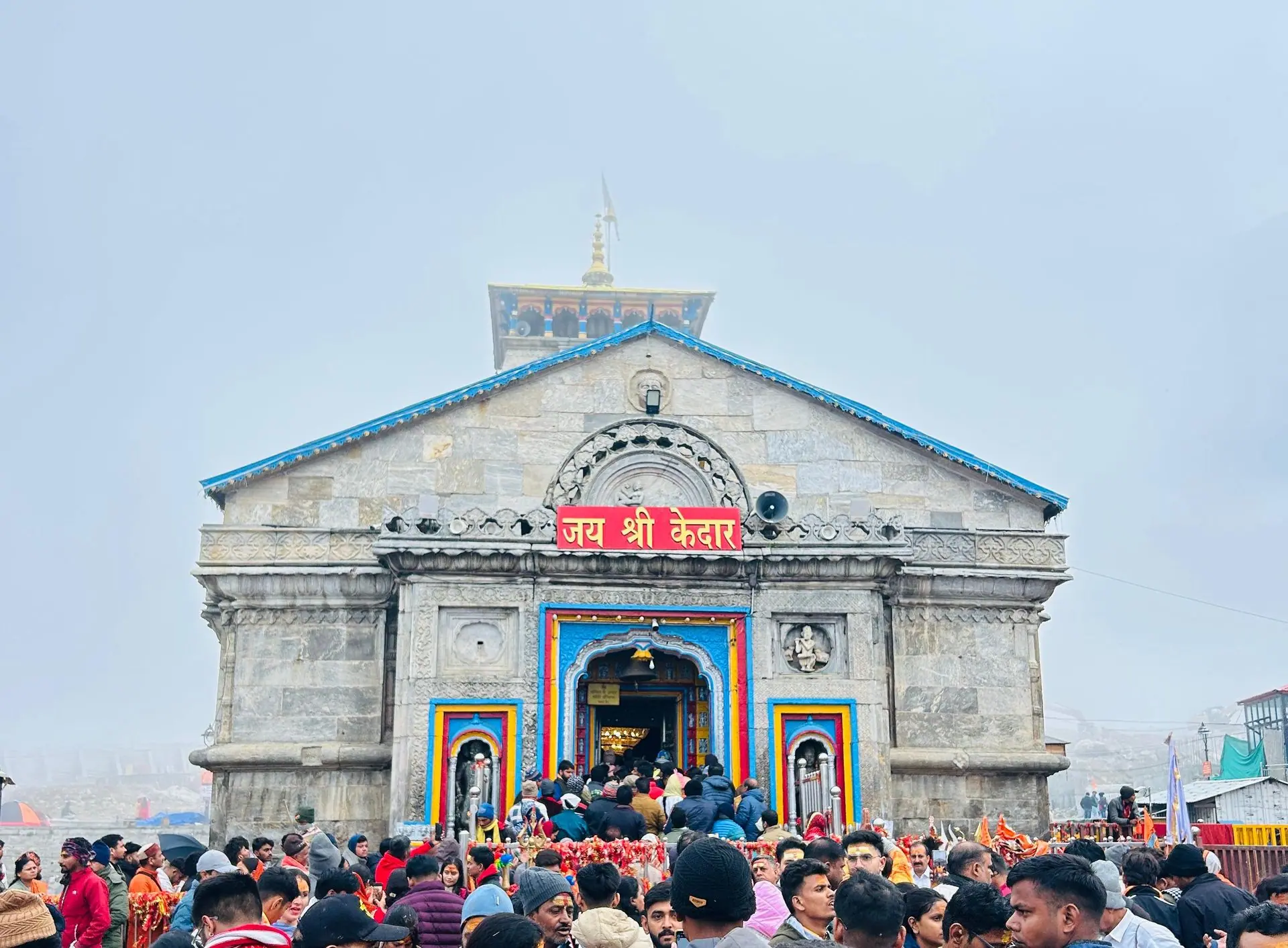 A large crowd gathers at the historic Kedarnath Temple in India amidst misty weather