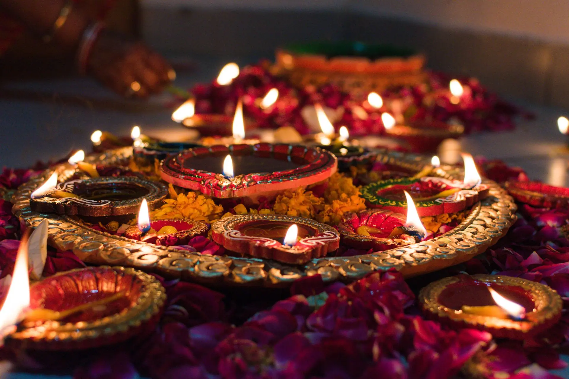 Beautifully lit traditional oil lamps (diyas) decorated with marigold flowers, celebrating Diwali in Jaipur, India