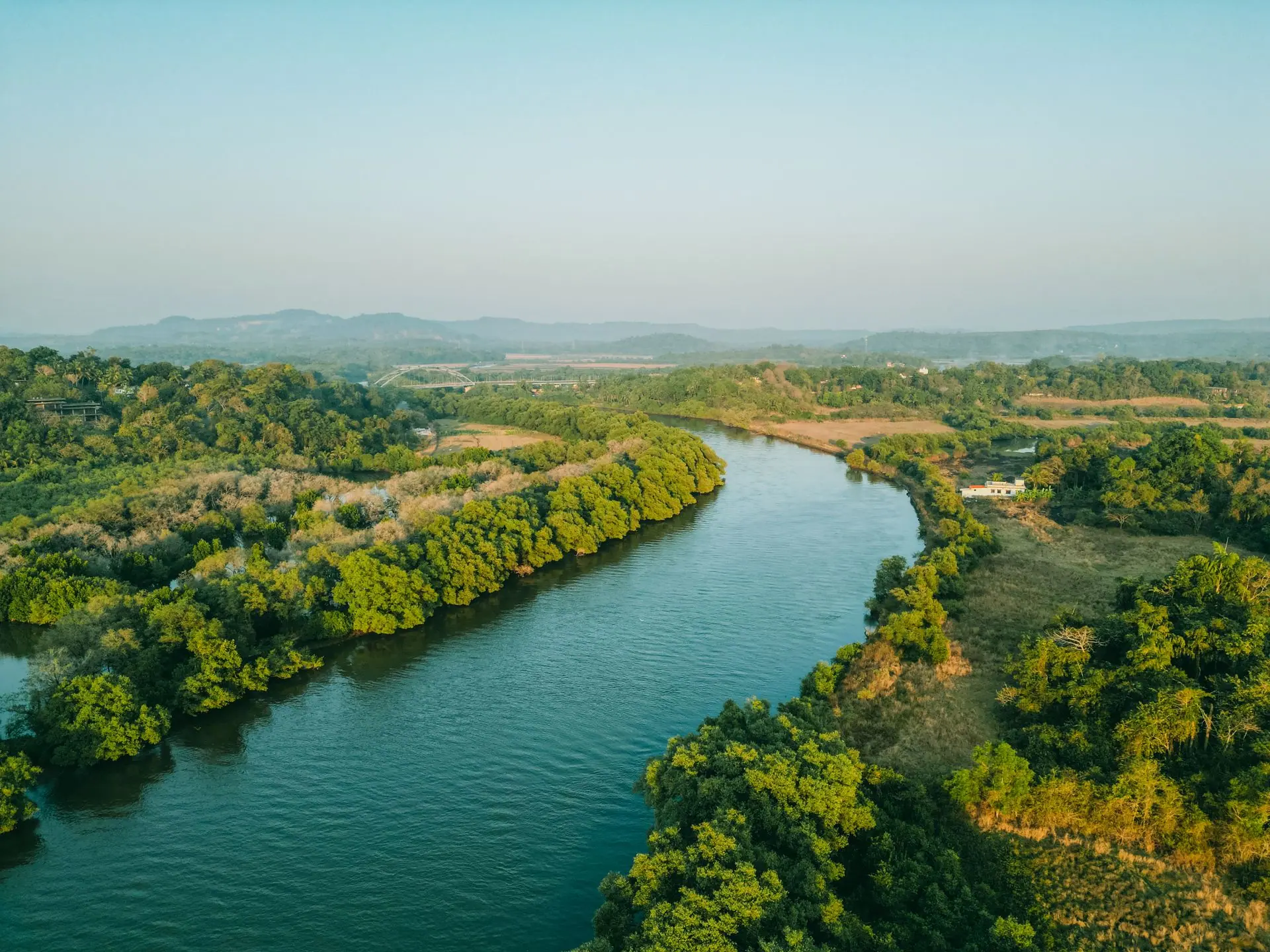 Breathtaking aerial view of a lush, meandering river landscape in Goa, India