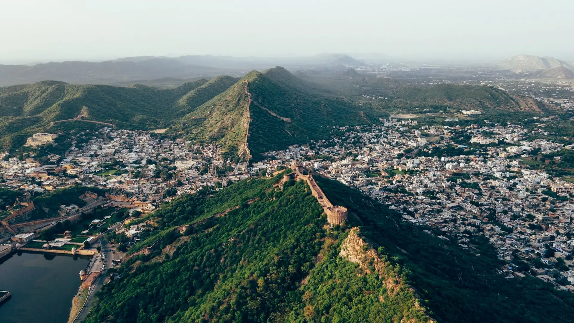 A stunning aerial view of Jaipur city, India, showcasing its historic fortifications and lush mountain ridge