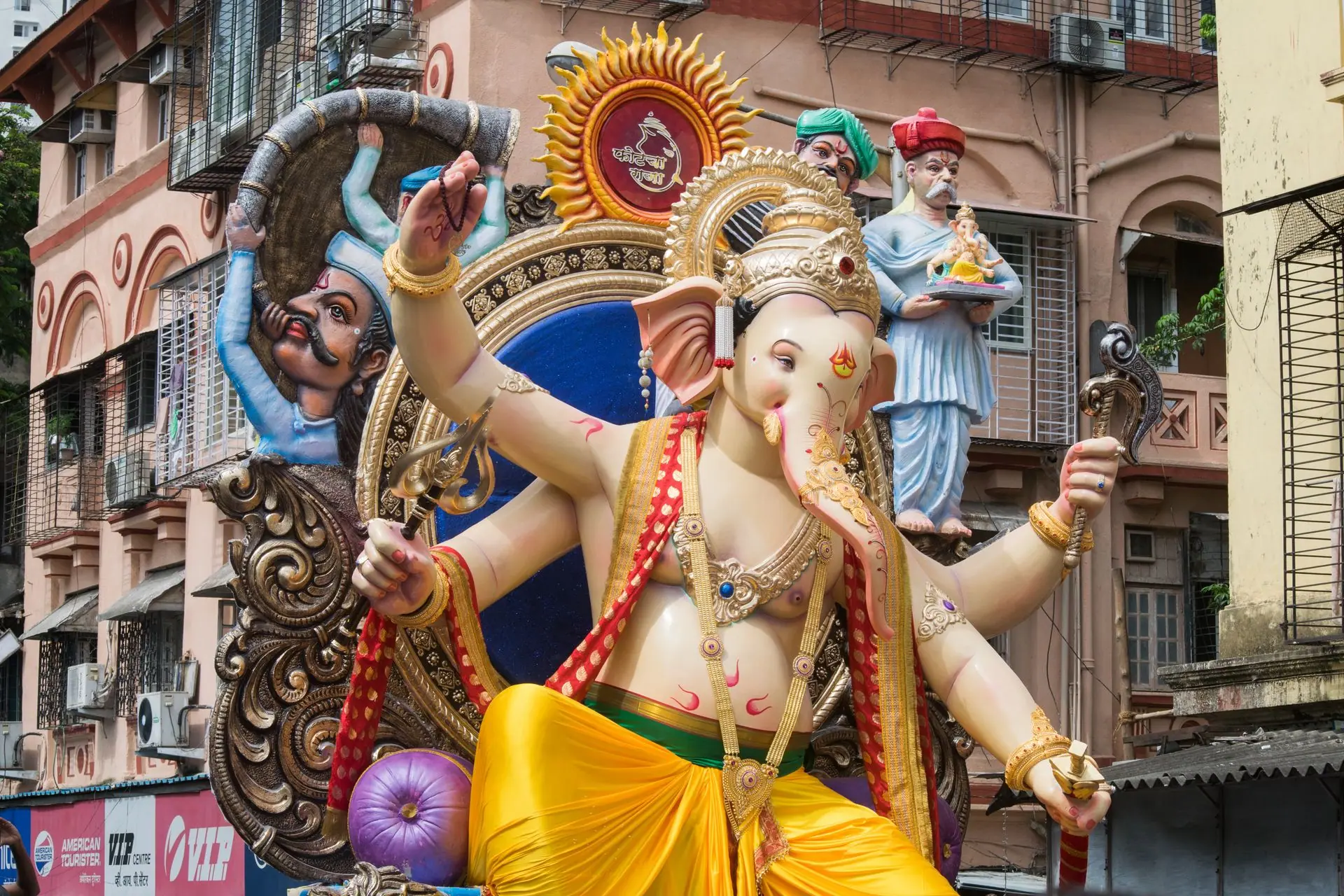 Colorful Ganesh statue amidst a bustling street during the festival in Mumbai, India
