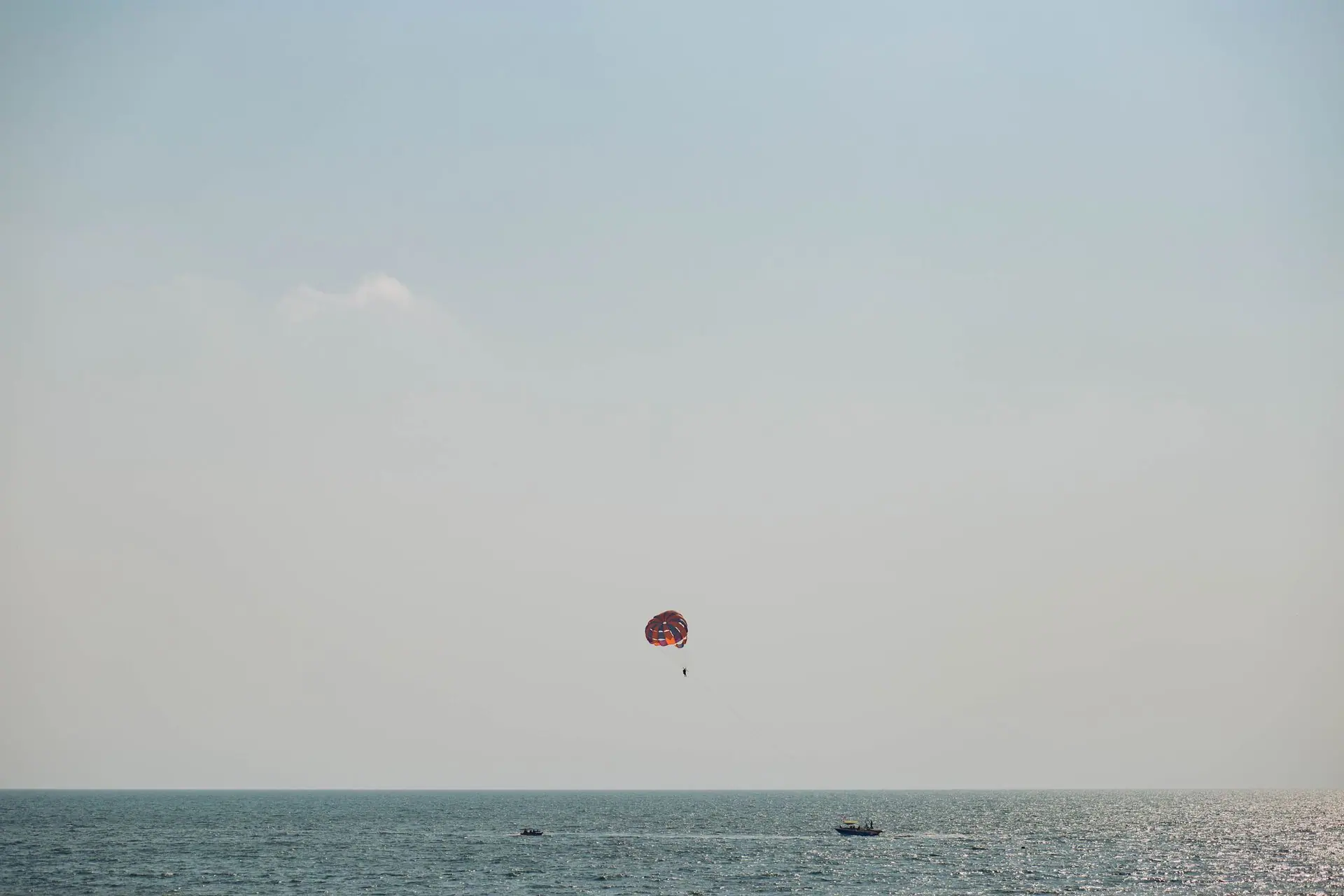 A thrilling parasailing experience over the vast Arabian Sea in Goa, captured on a sunny day