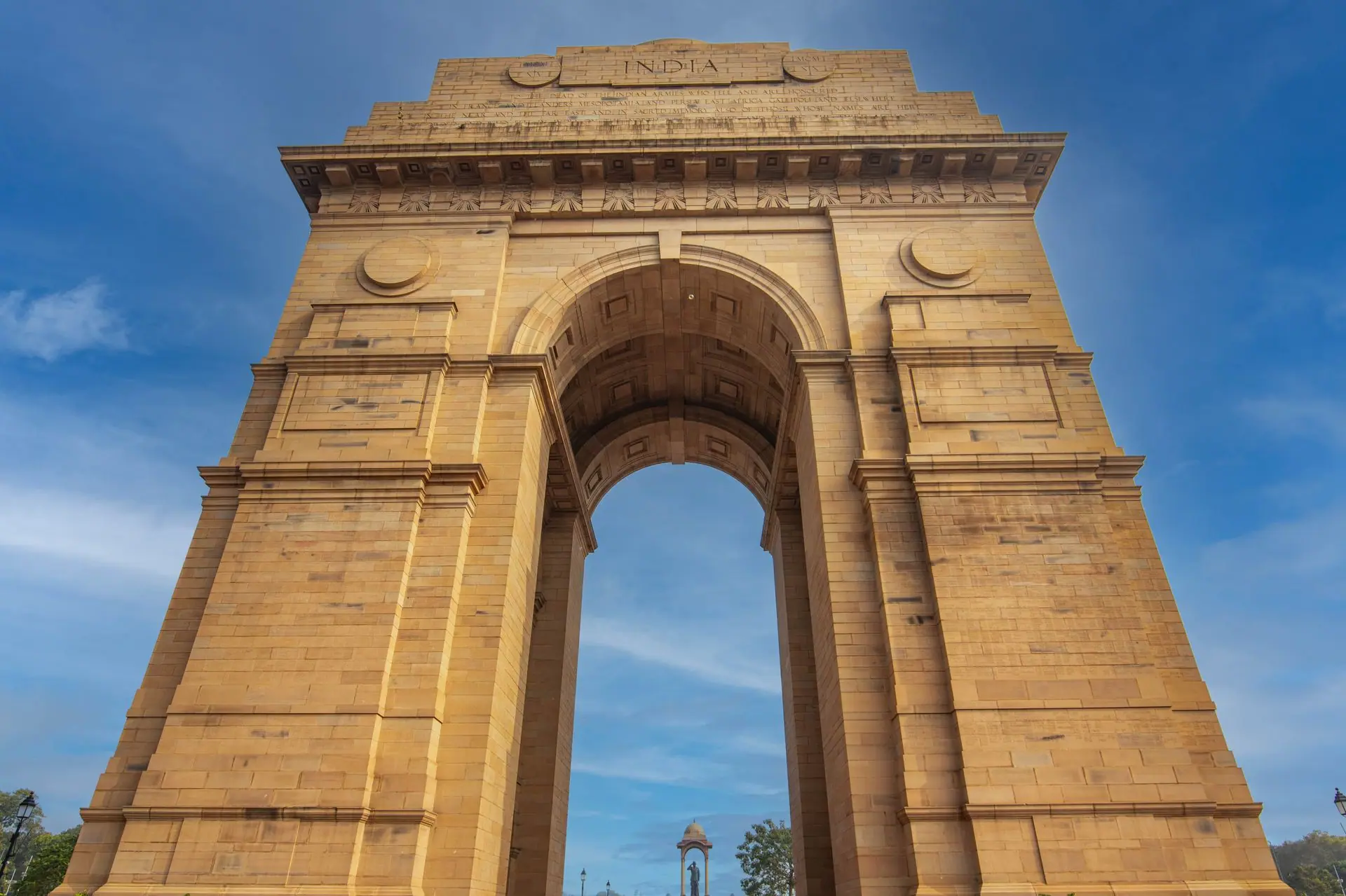 Stunning low-angle shot of the iconic India Gate monument in Delhi against a blue sky