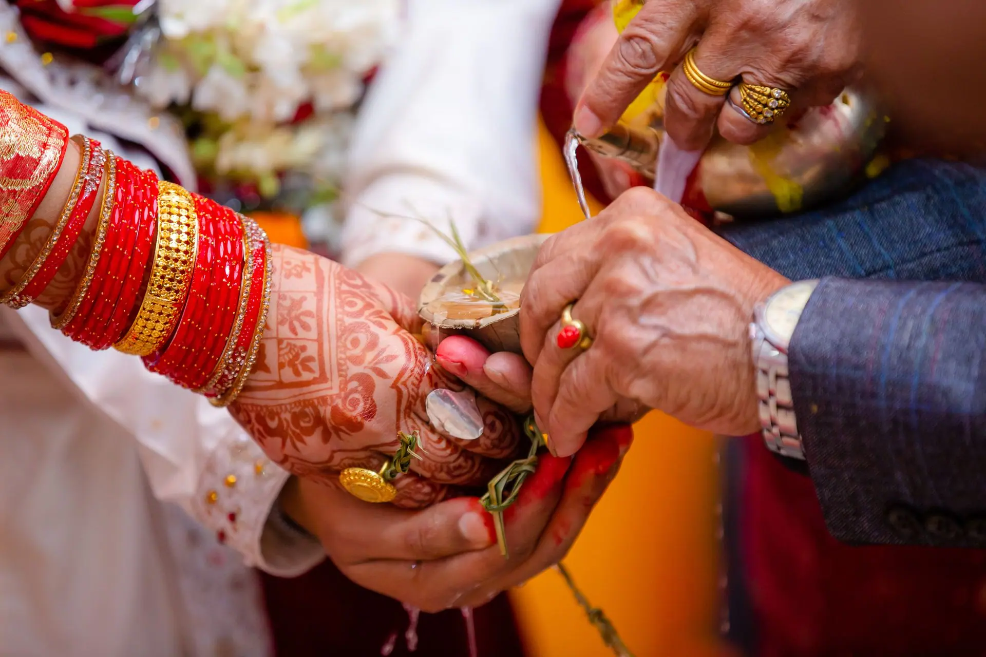 Colorful close-up of traditional Indian wedding ritual with henna and red bangles