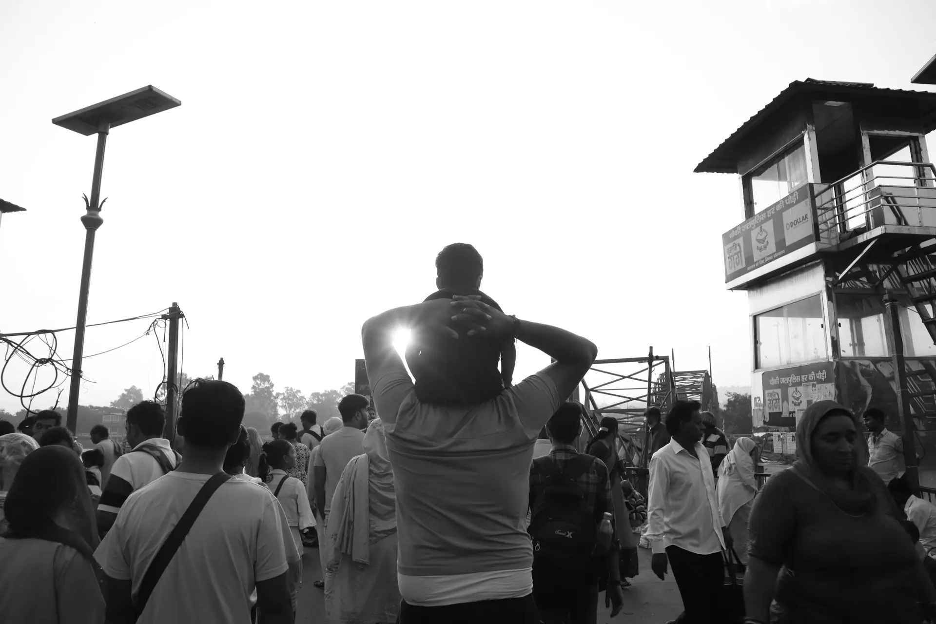 Black and white photo of a busy street scene in Haridwar, India with pedestrians
