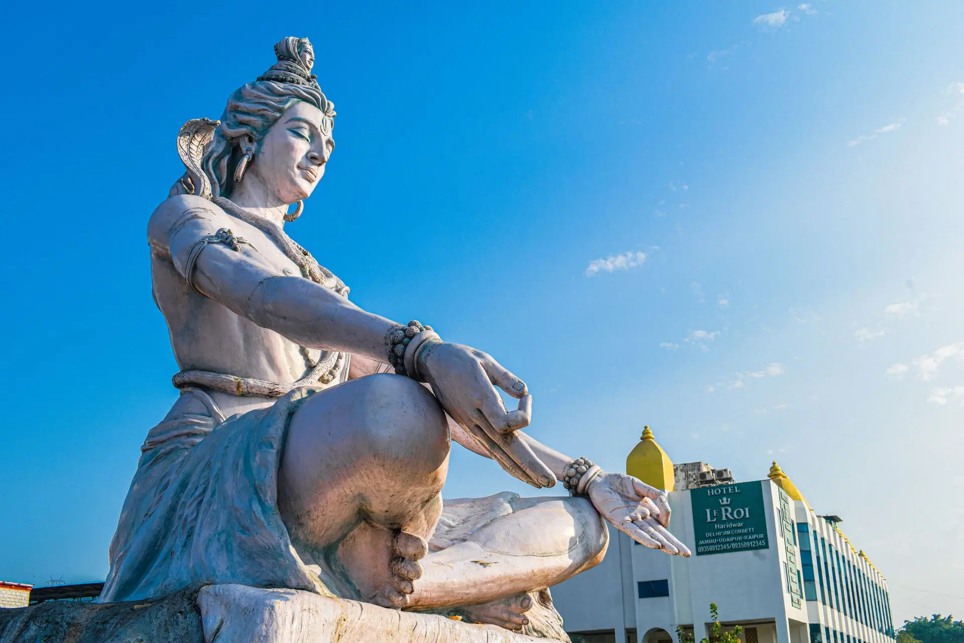 Magnificent low-angle view of Lord Shiva statue against a blue sky in Haridwar, India