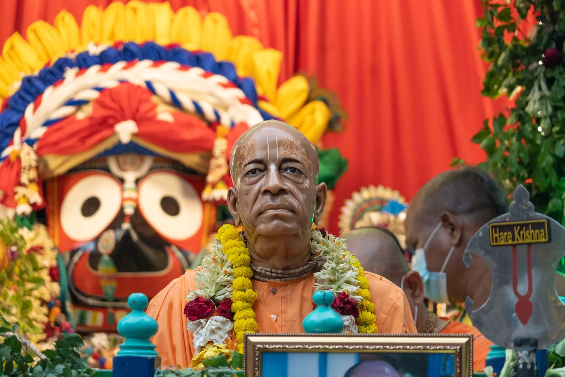 Colorful Hindu festival with Jagannath deity and a spiritual leader's statue
