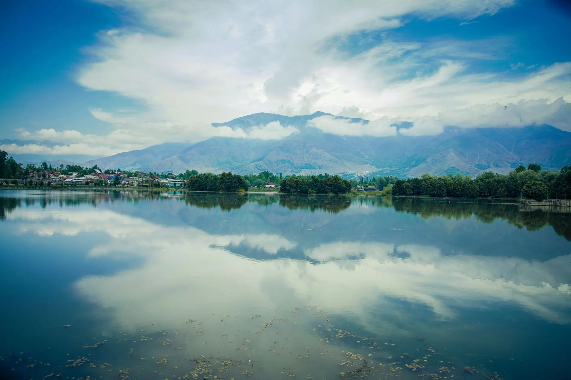 Peaceful landscape of Dal Lake with mountains and clear reflections in Srinagar, India