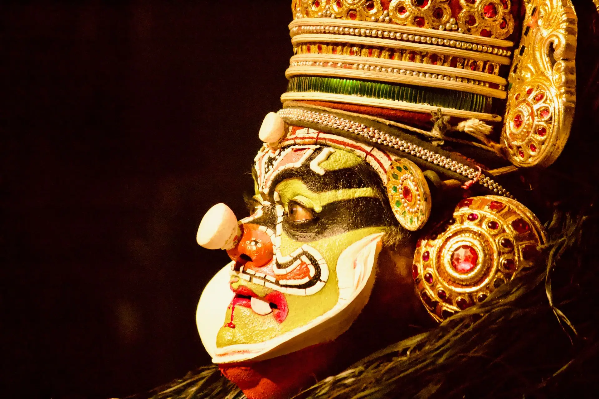 Close-up of a Kathakali performer with intricate face paint and traditional attire, showcasing Indian culture