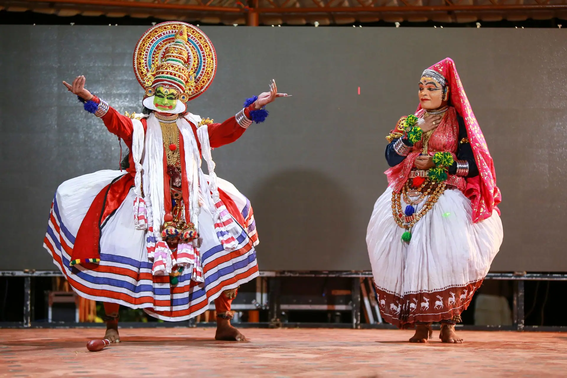 Vibrant Kathakali dancers performing in traditional costumes at a cultural event in Kerala, India