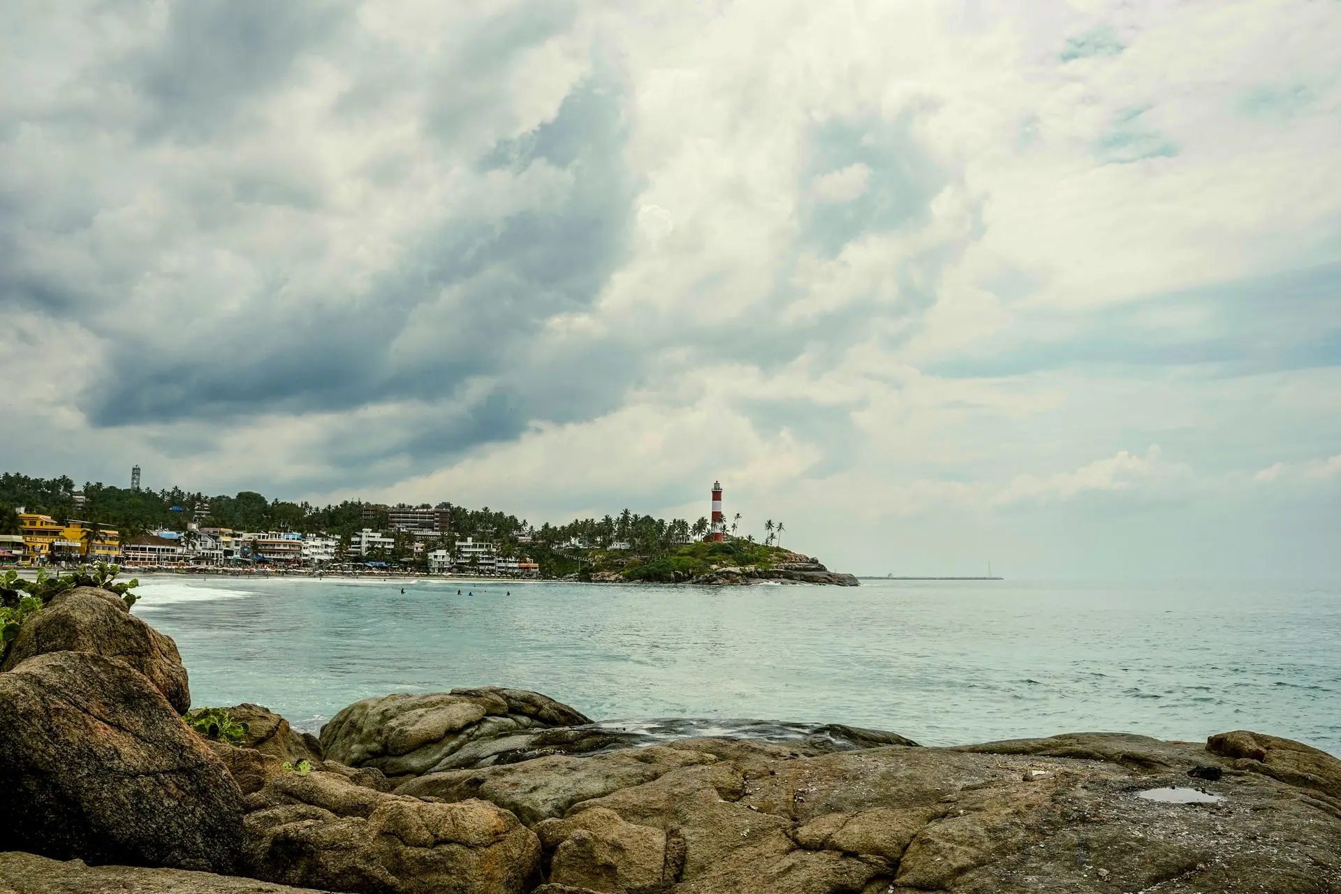 A beautiful landscape of Kovalam Beach with its iconic lighthouse under dramatic skies
