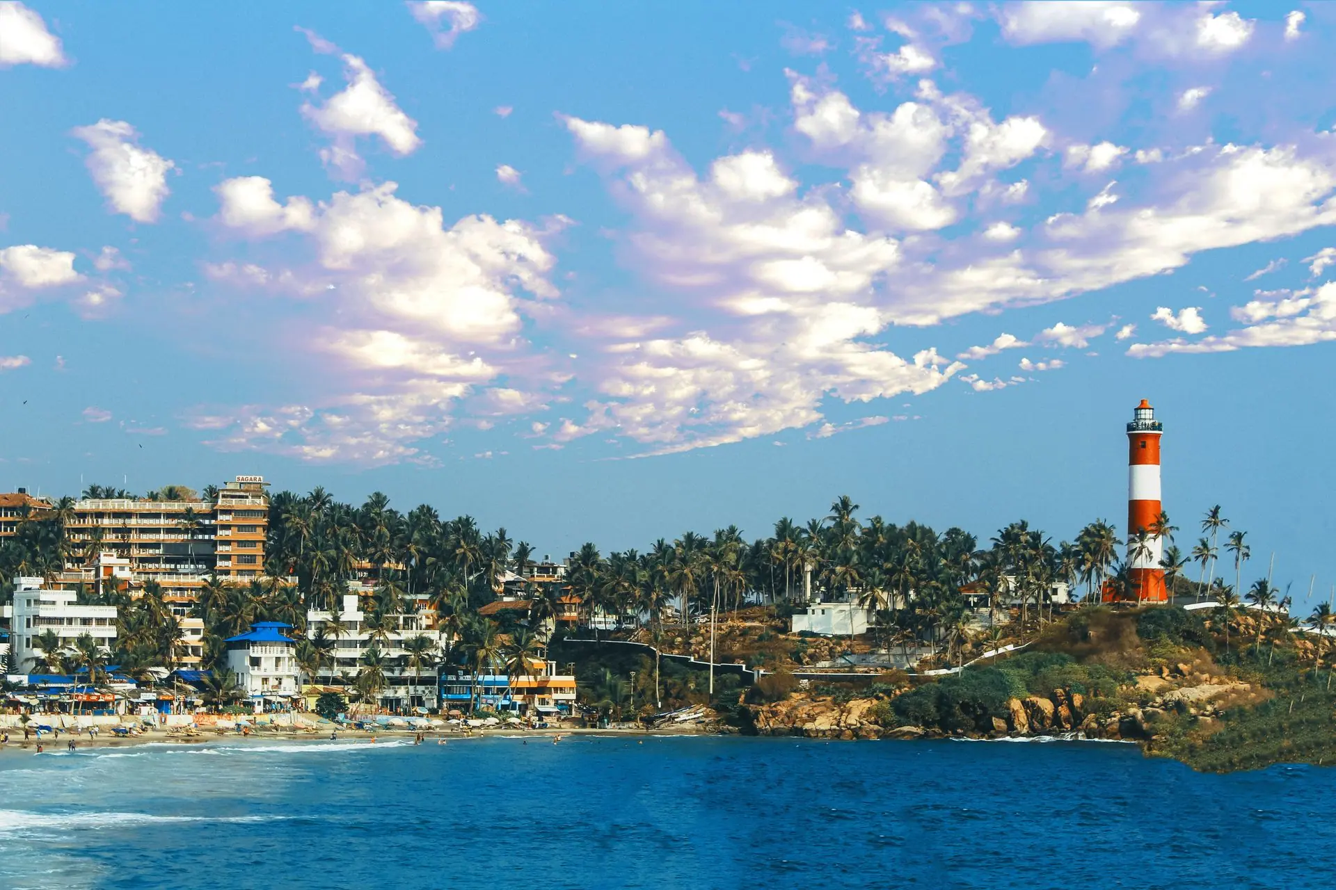 Aerial view of the iconic lighthouse and bustling beachfront in Kovalam, India