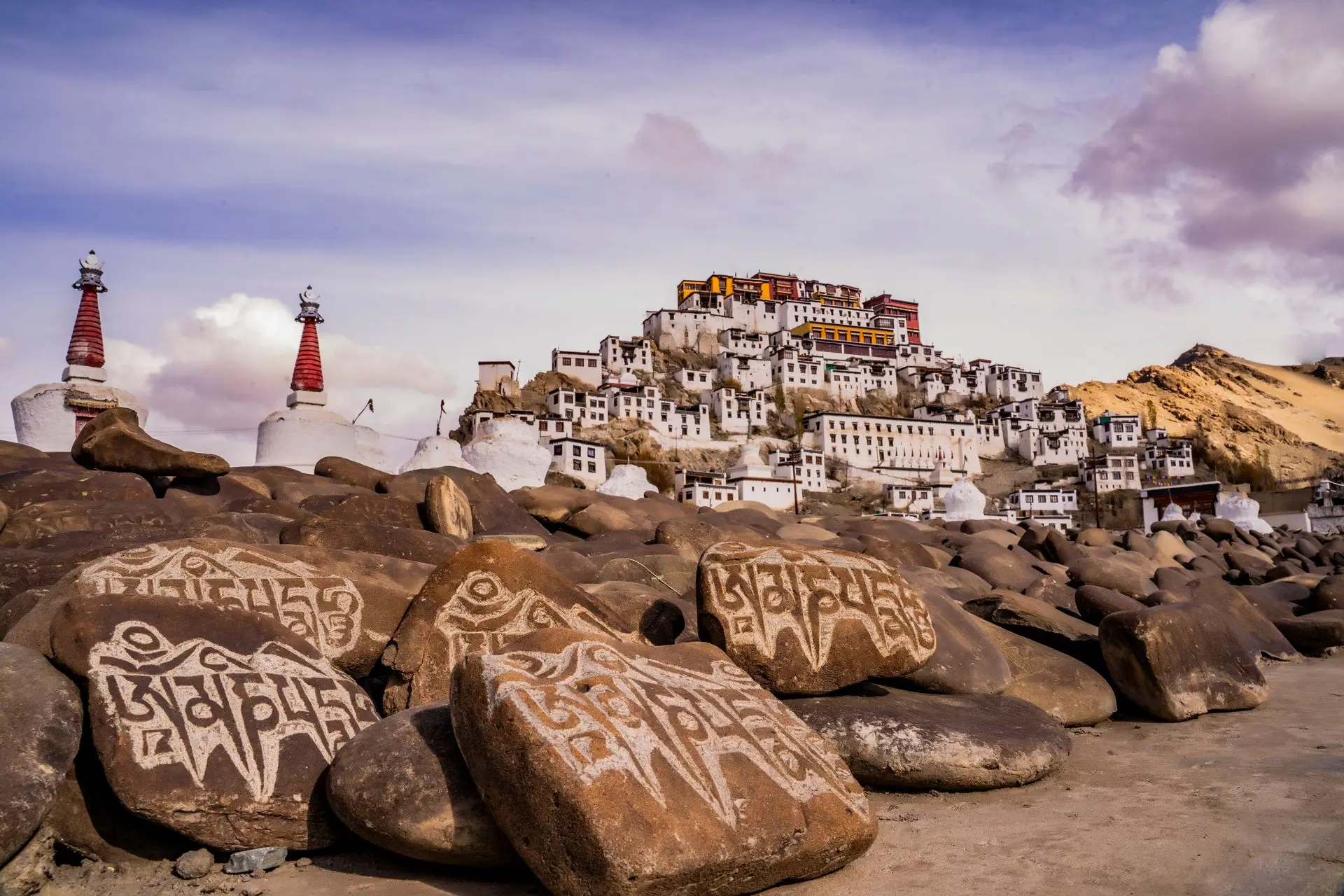 Dramatic view of a Tibetan monastery surrounded by sacred mani stones in Ladakh, India