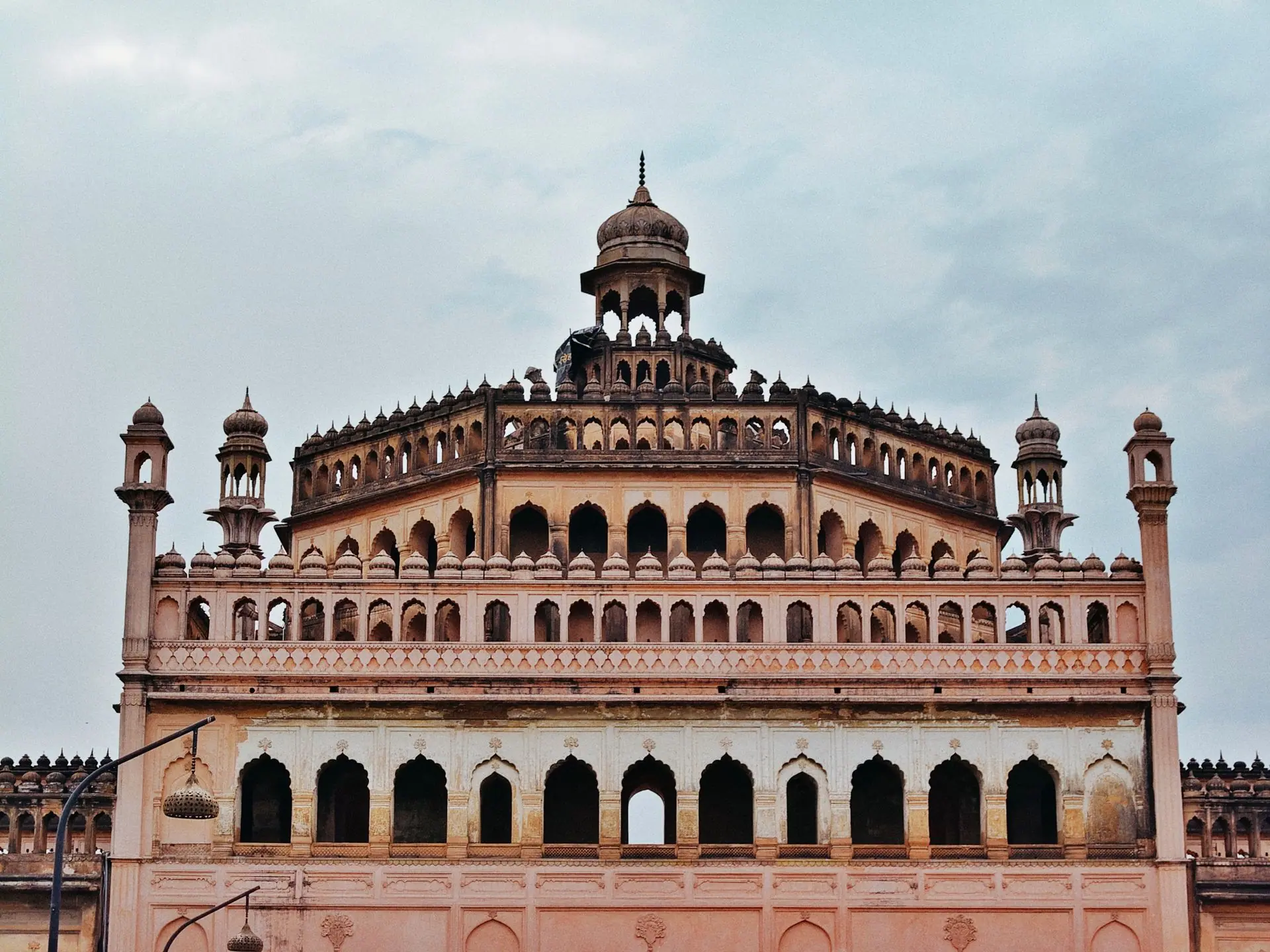 Capture of the Bara Imambara showcasing its Mughal architecture against a cloudy sky