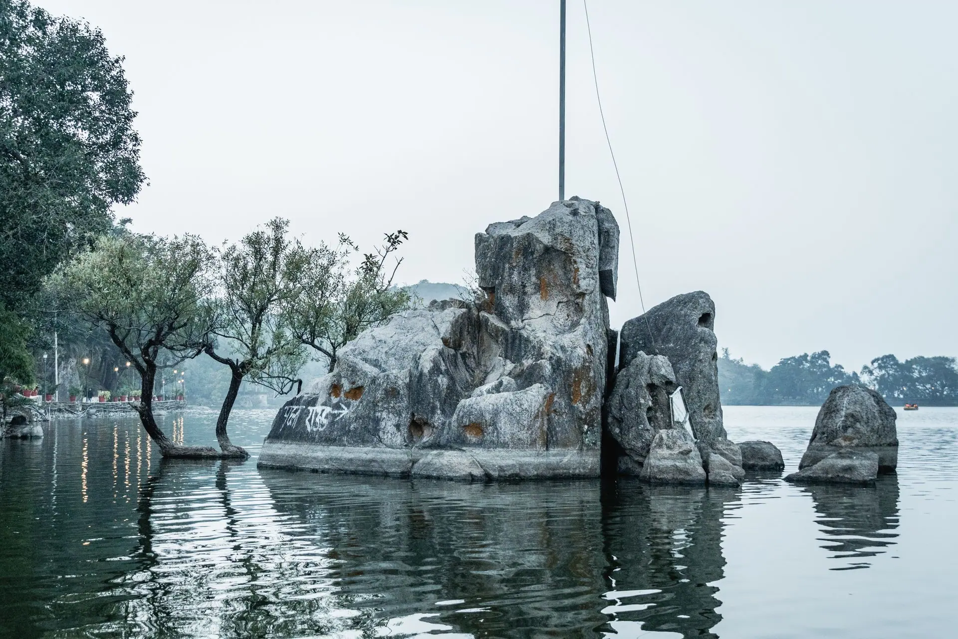Beautiful rock formation and trees reflecting in a tranquil lake at Mount Abu, Rajasthan, India