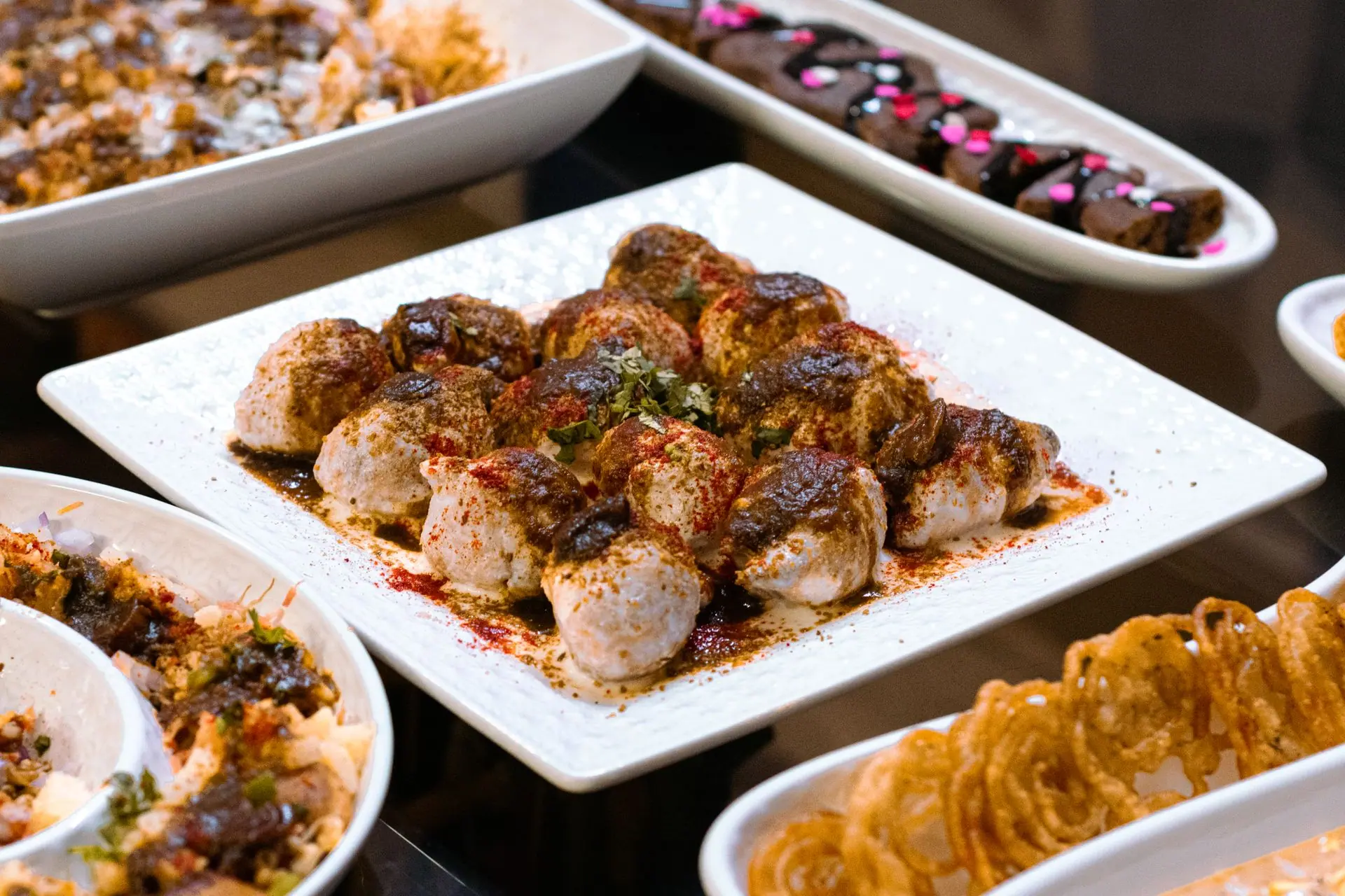 A vibrant display of Indian street food featuring dahi vada, showcasing rich spices and diverse flavors