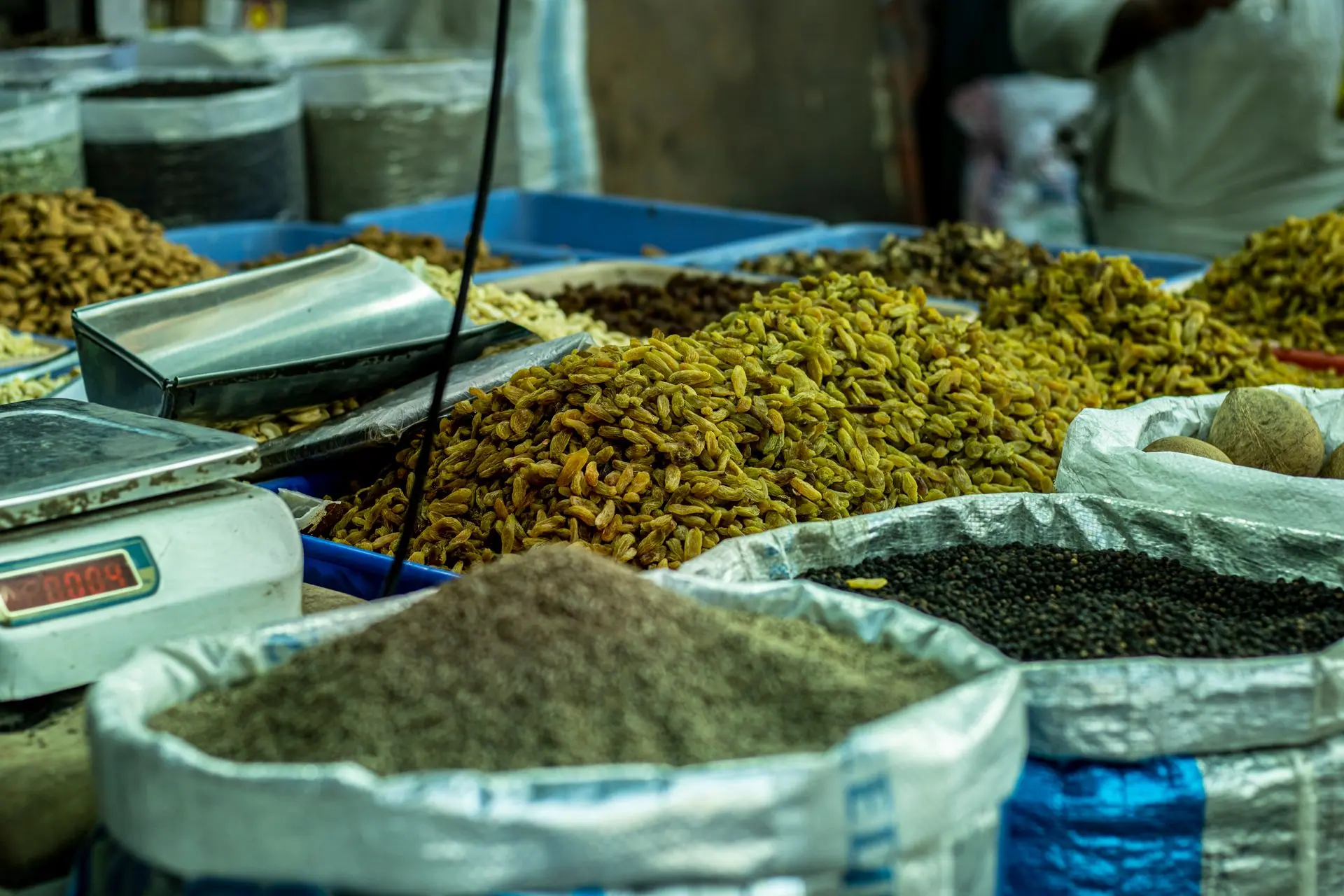 A vibrant spice market stall in Delhi displaying various spices and grains in sacks