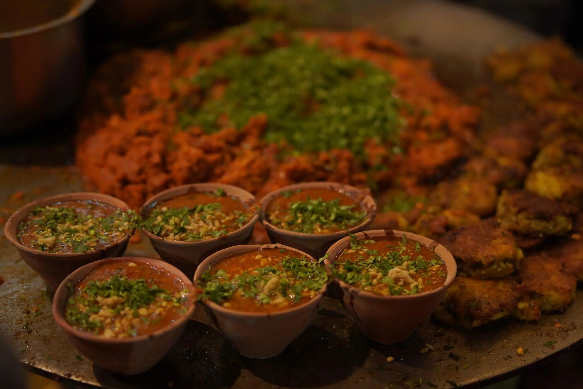 Close-up of Indian street food with vibrant toppings and spices in clay pots