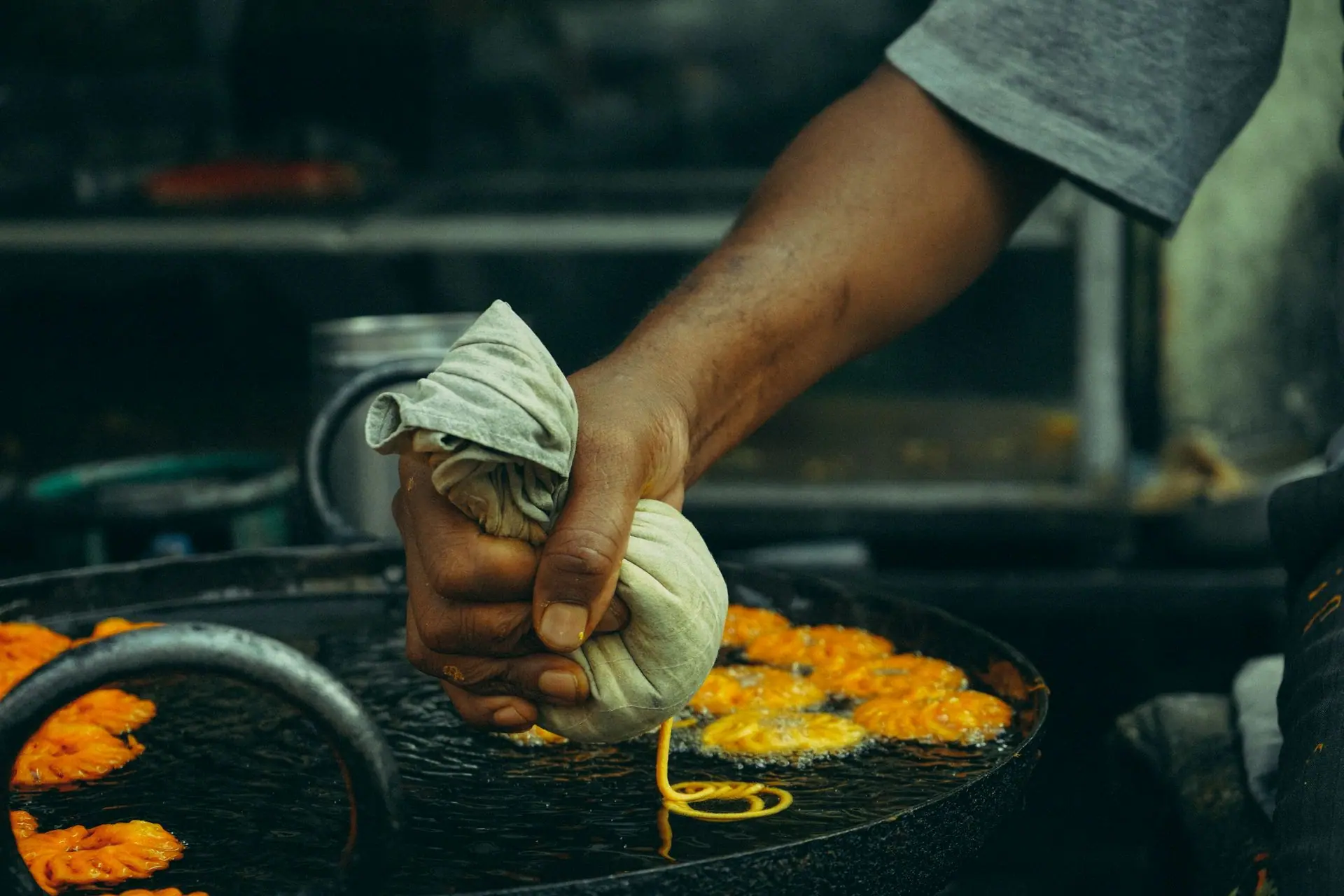 Close-up of a street vendor making jalebi, a popular deep-fried Indian sweet treat
