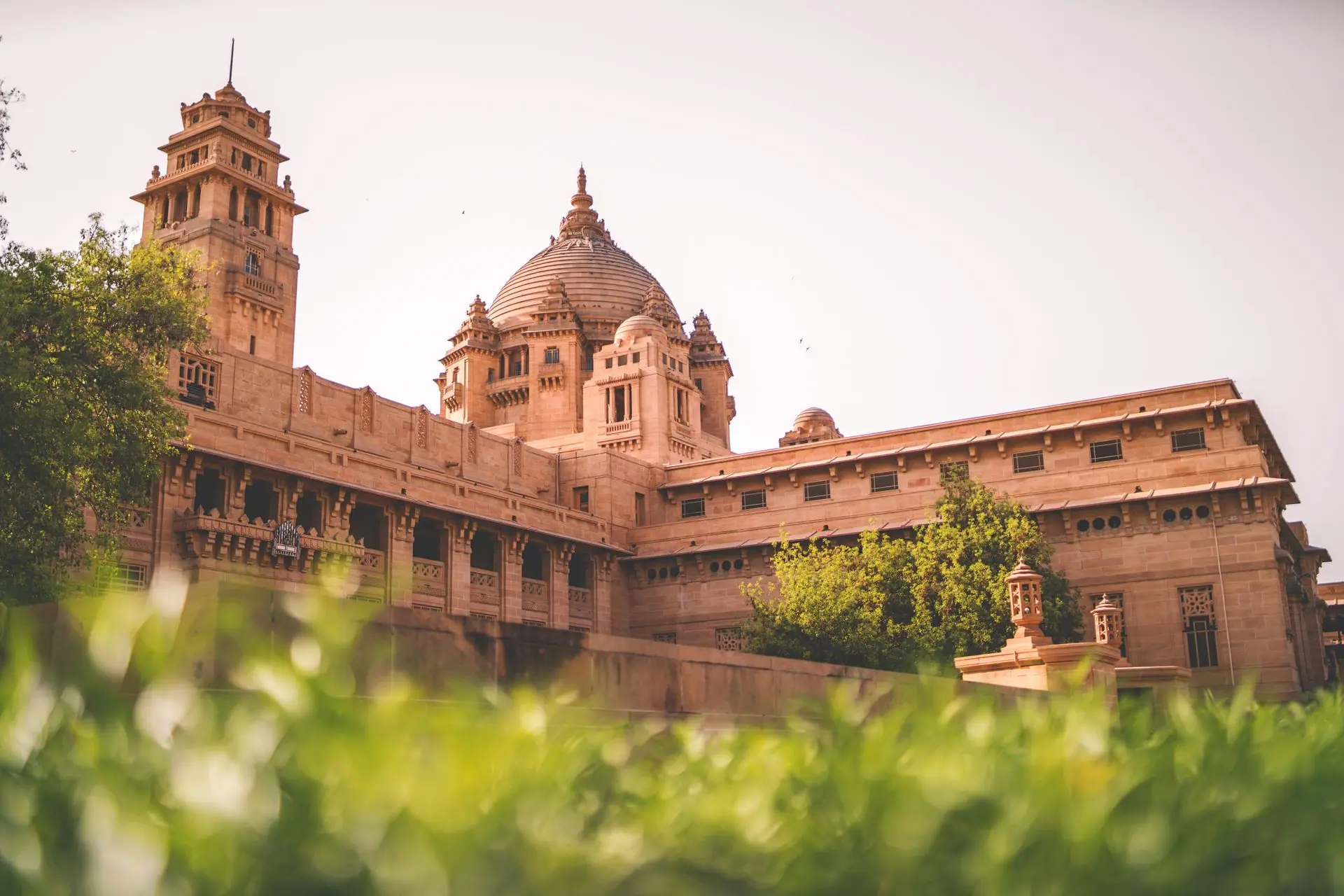 Majestic Umaid Bhawan Palace in Jodhpur, India, captured in daylight with lush greenery