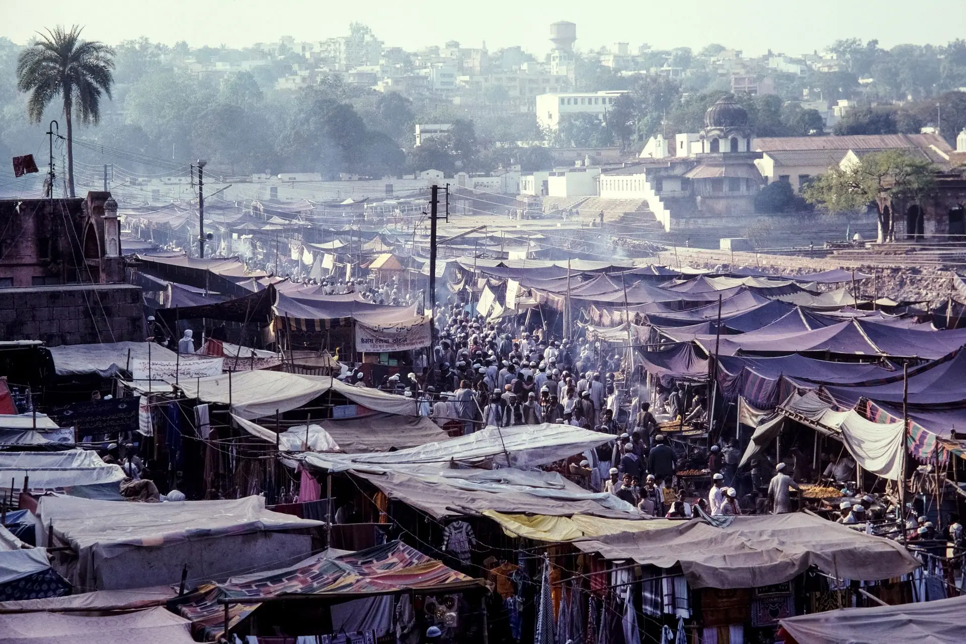 A bustling outdoor market in Pushkar, Rajasthan, India, showcasing a vibrant atmosphere and diverse crowd