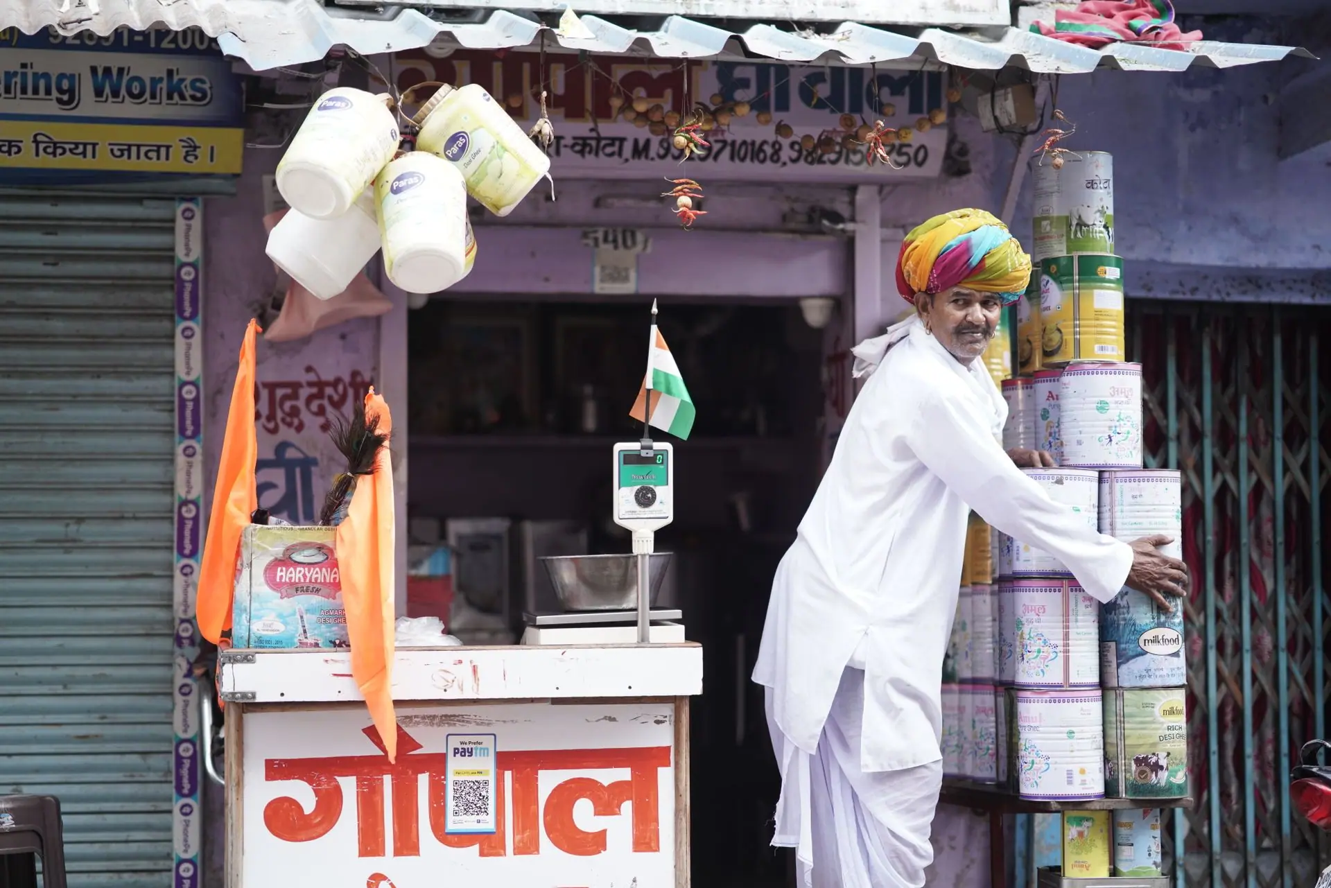 A vibrant Indian merchant arranging products outside his shop in Kota, Rajasthan