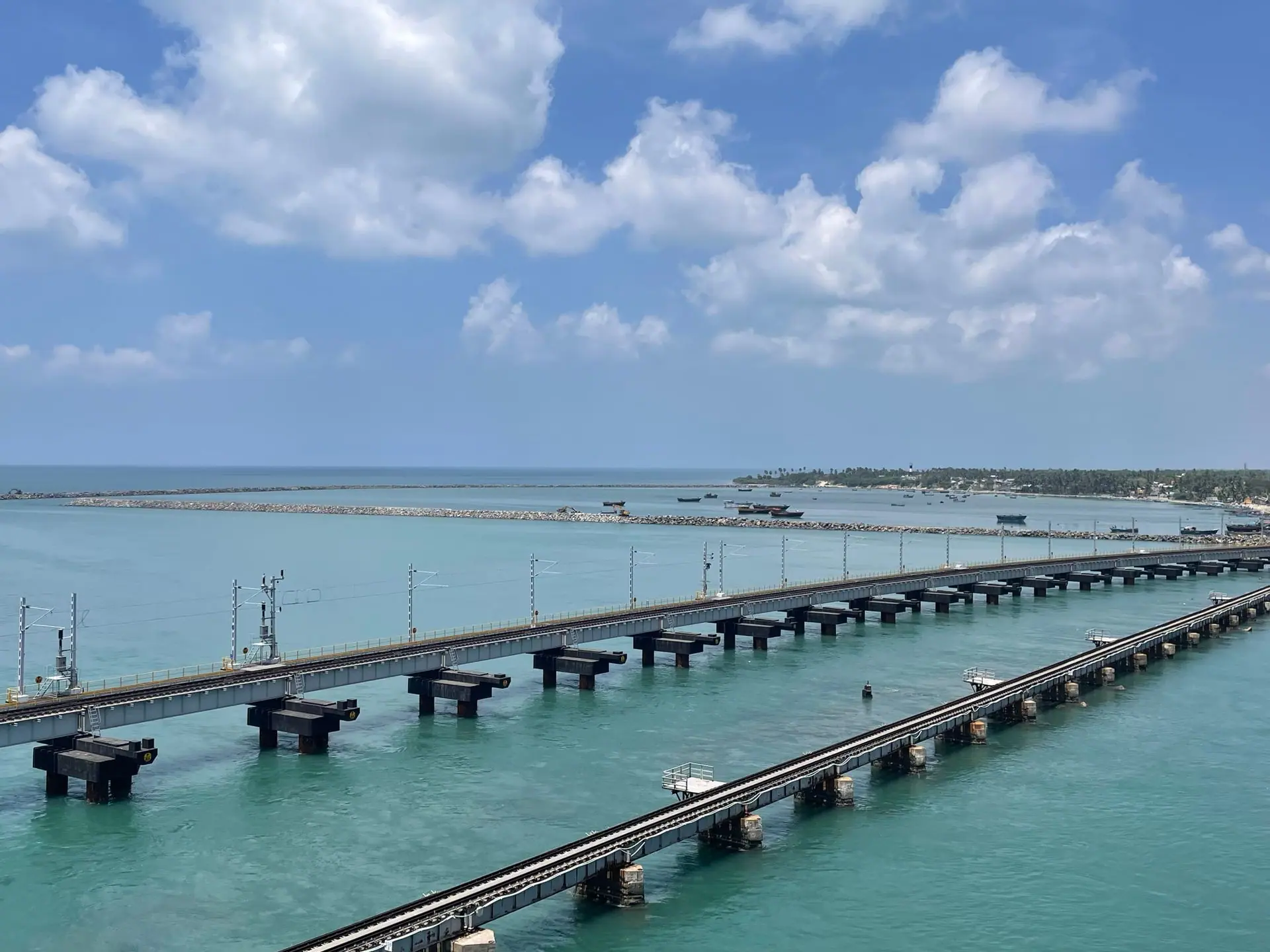 Scenic view of the iconic Pamban Bridge connecting Rameswaram, India, over vibrant turquoise waters under a bright sky