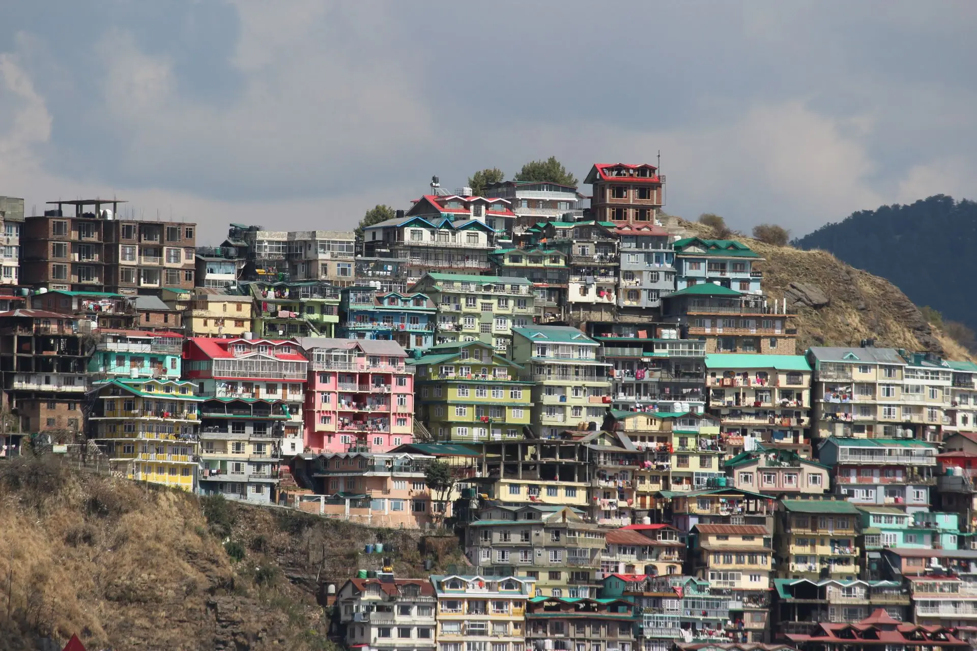 Vibrant, colorful homes densely packed on a hillside in Shimla, India