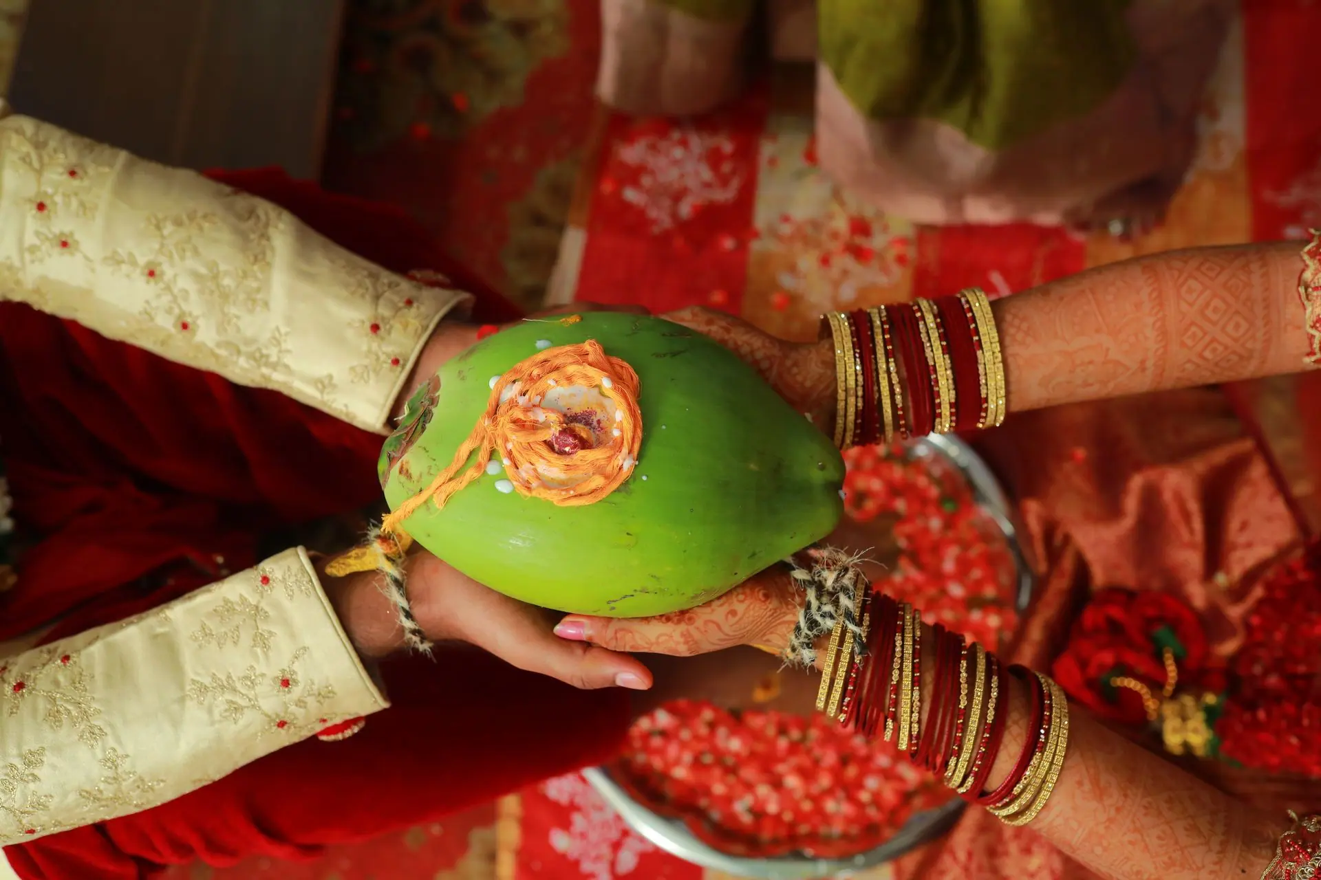 Close-up of a couple holding a decorated coconut in a traditional Indian wedding ceremony in Tirupati