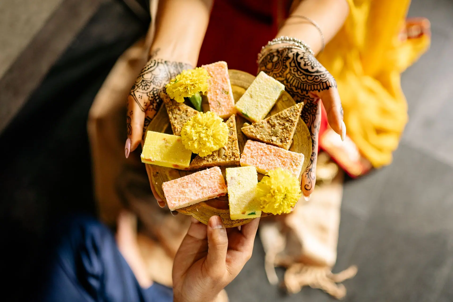 Bright Indian sweets and marigolds for Diwali, featuring intricate henna designs